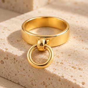 Bague L’Anneau Suspendu en or 18 carats posée sur une pierre claire